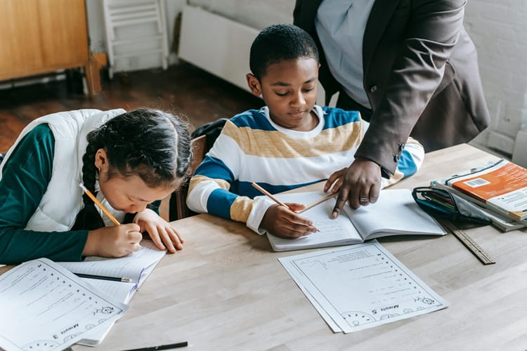 teacher helping students read (1)